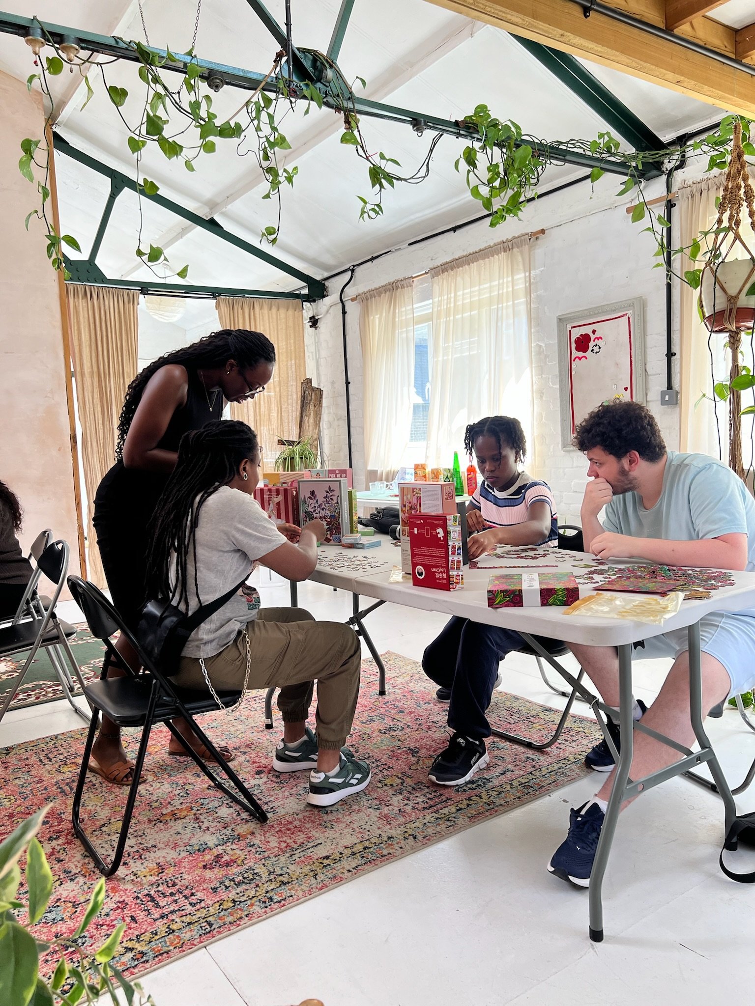 Four people gathered round a table under hanging plants