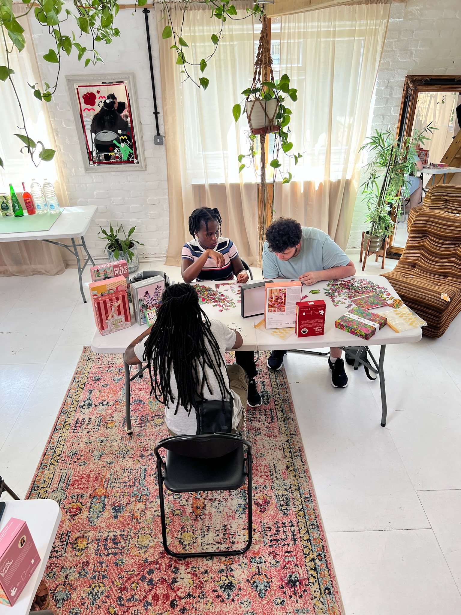 Three people piecing together a colourful floral puzzle