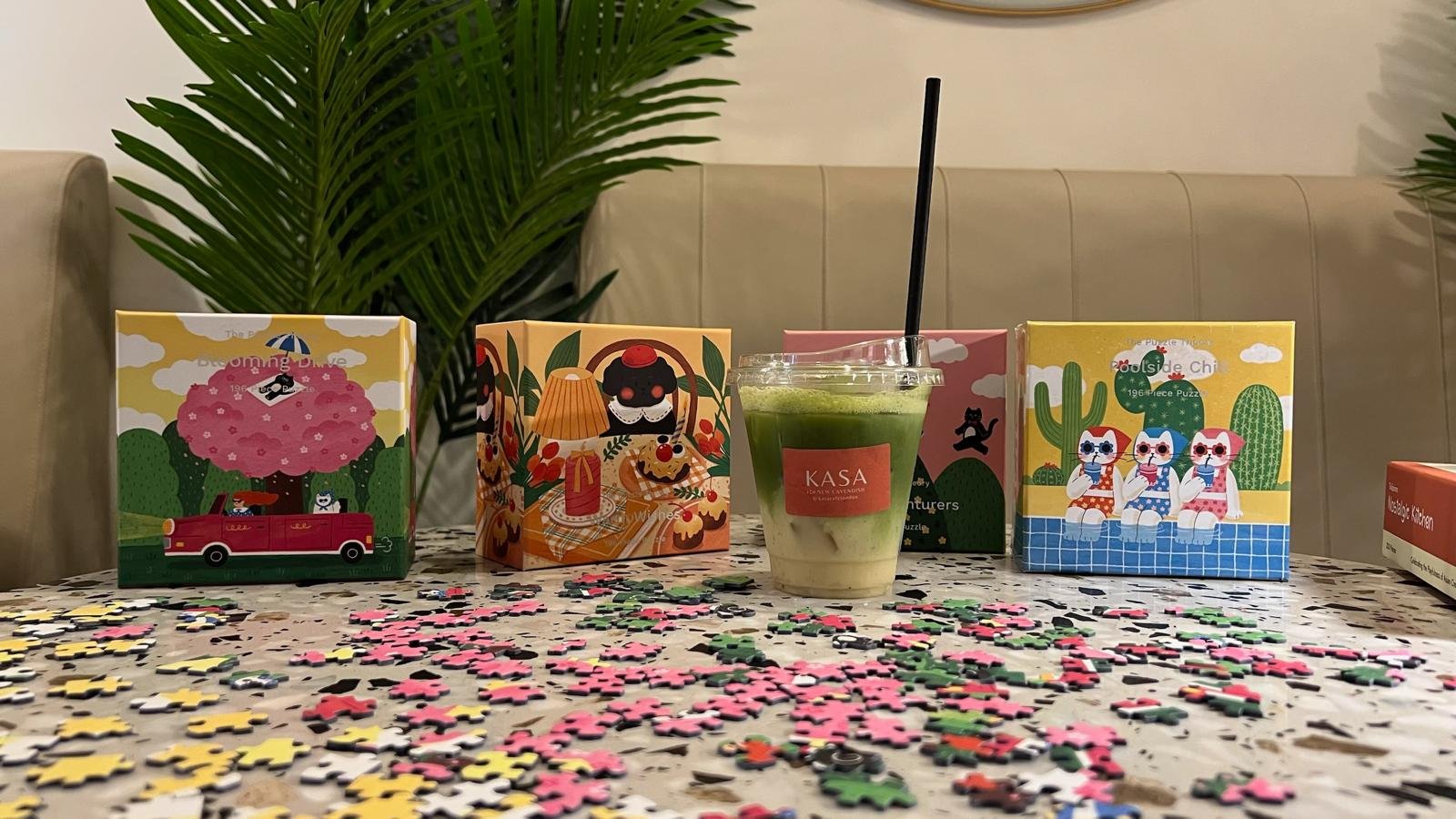 Puzzle boxes and an iced matcha from Kasa Café on the table