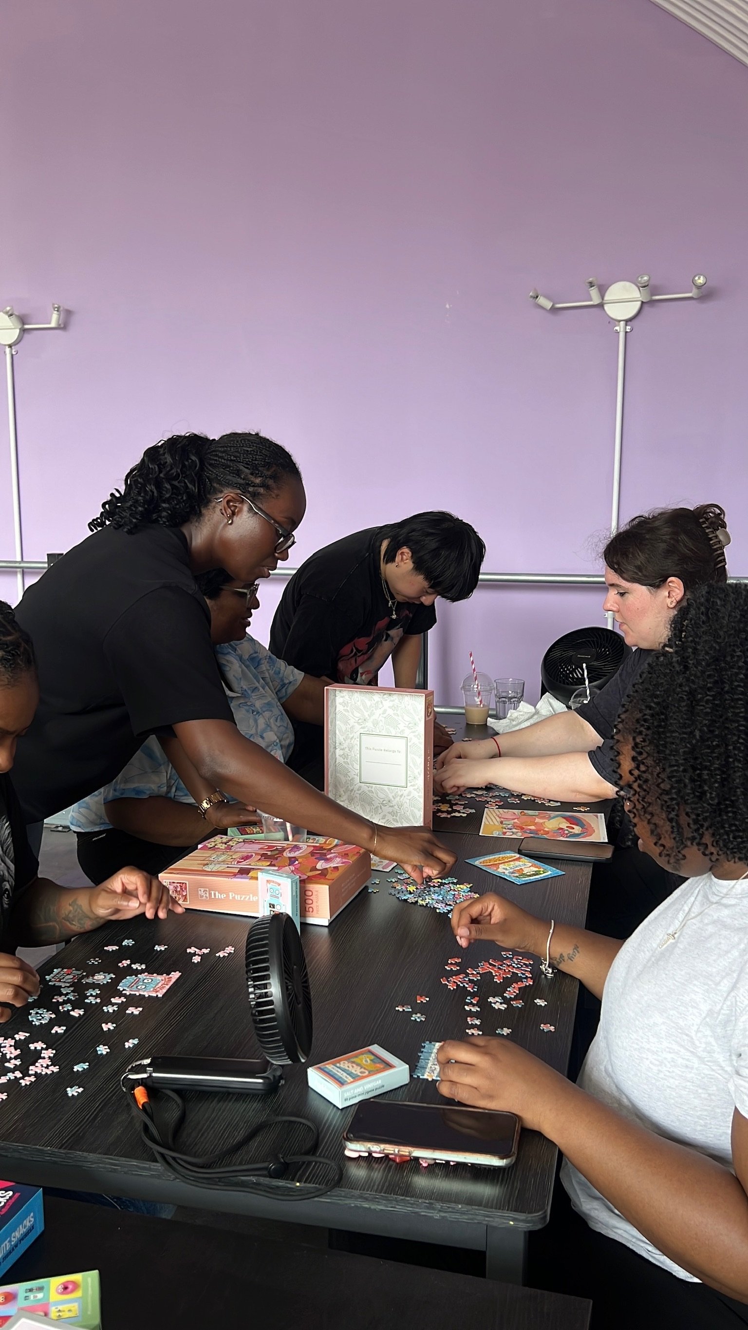 A group working across two tables of puzzles
