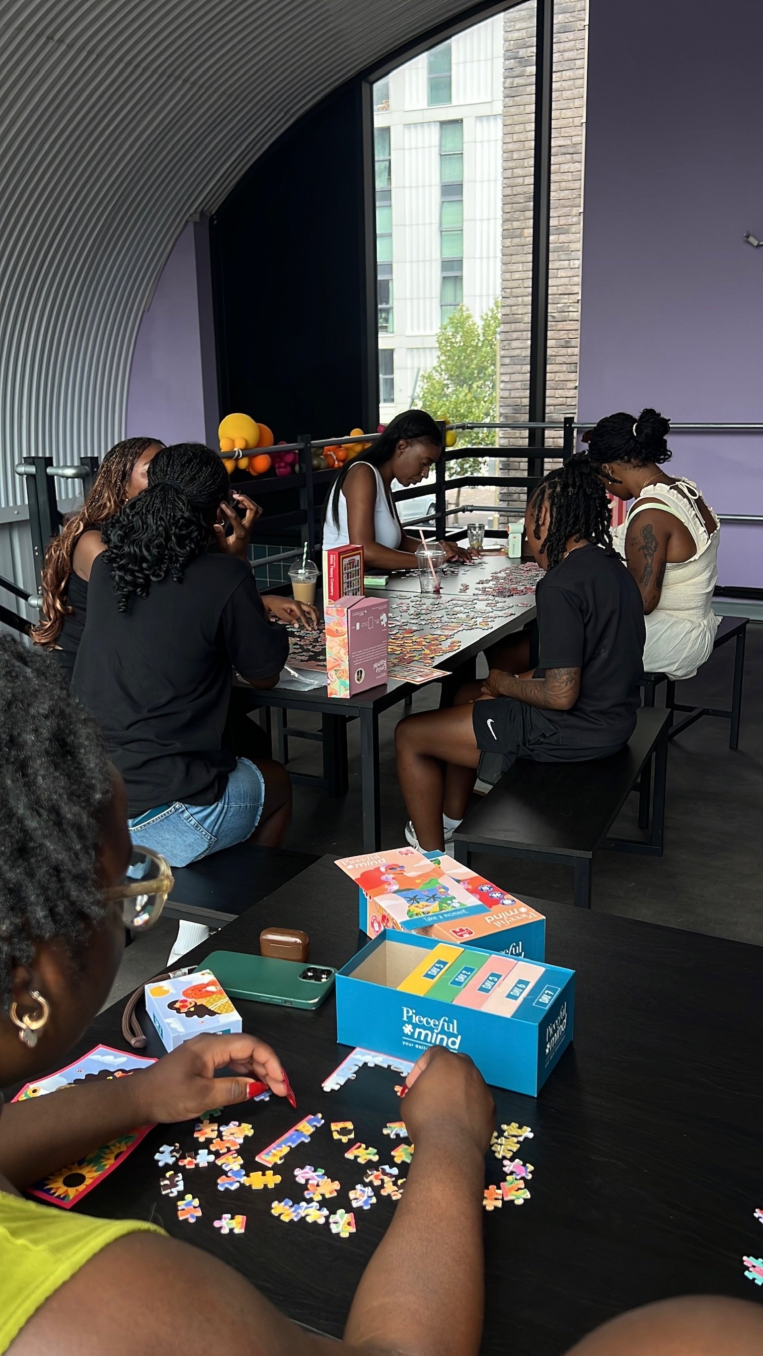 A group gathered round a table under a balloon garland
