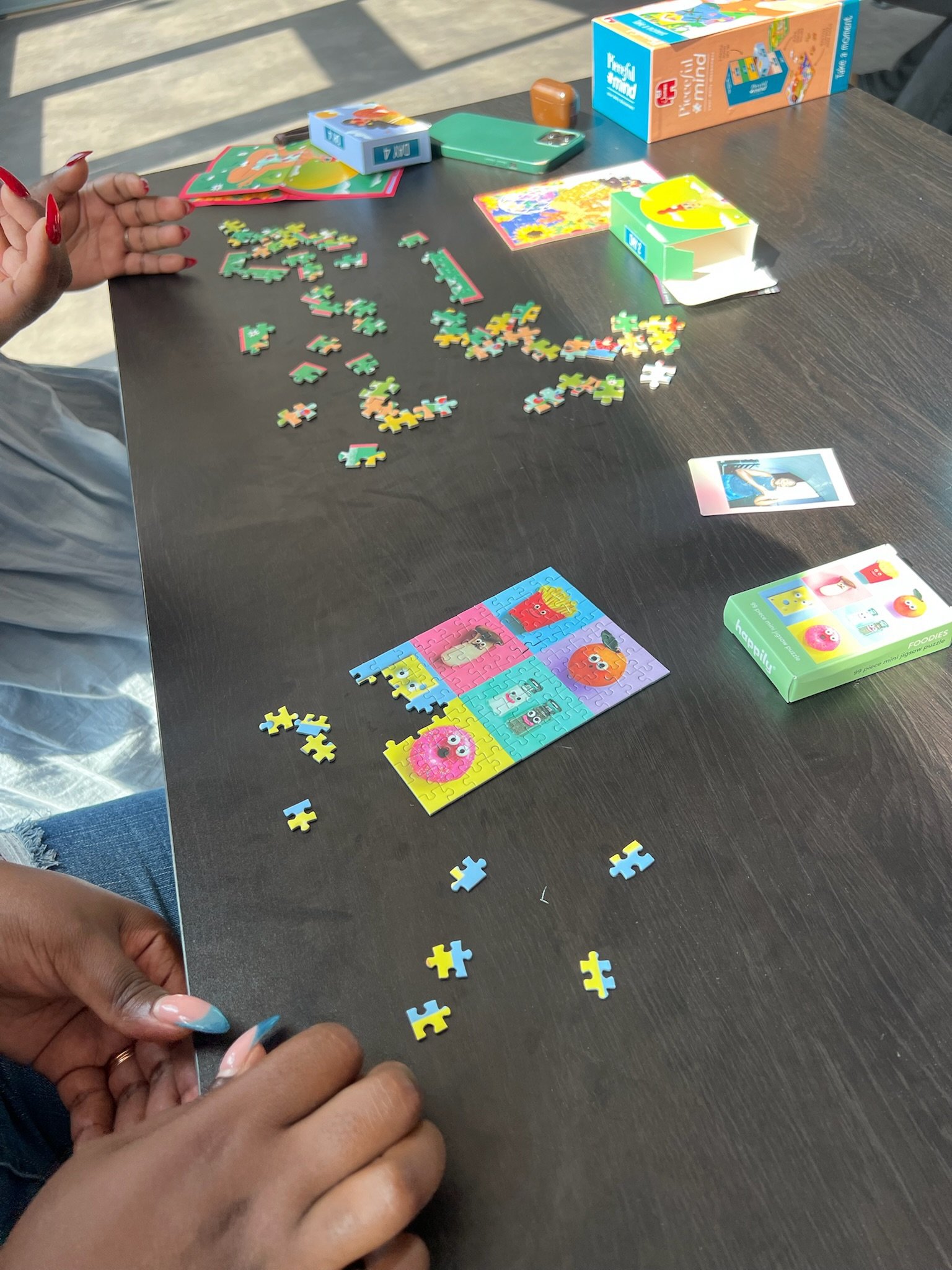 Close-up of hands piecing together a mini Foodies puzzle