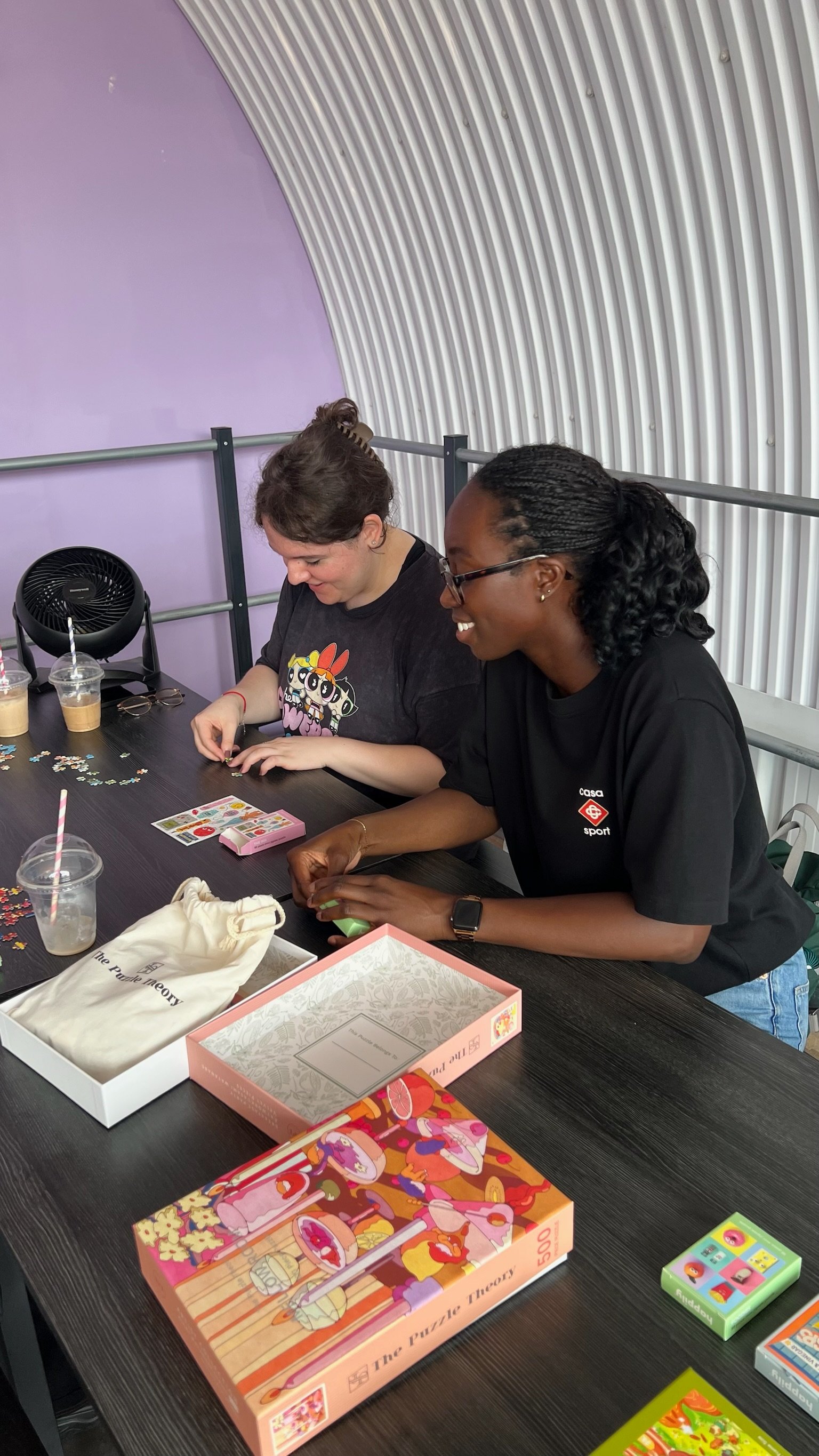 Two people laughing together over a puzzle