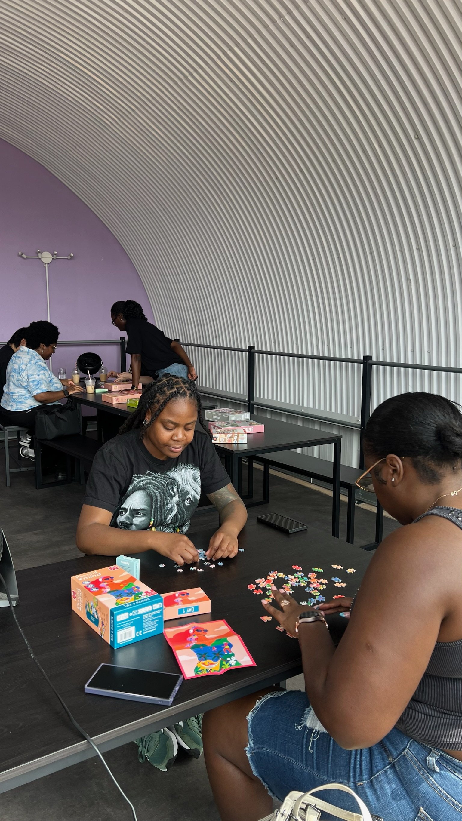Two women sitting at a table working on a puzzle